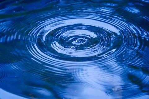 Water droplets affect the surface, forming rings on the surface. 스톡 사진