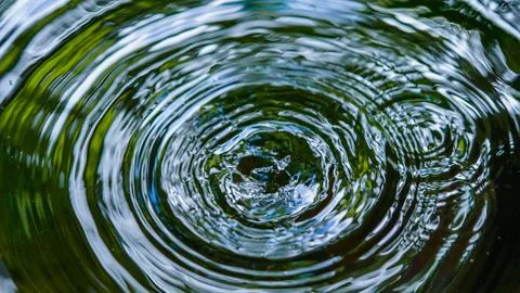 Water droplets affect the surface, forming rings on the surface. 스톡 사진