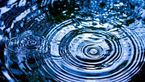 Water droplets affect the surface, forming rings on the surface. 스톡 사진