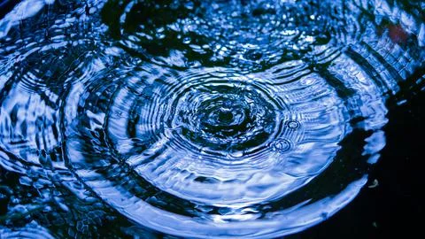 Water droplets affect the surface, forming rings on the surface. 스톡 사진