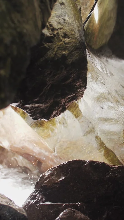 Water droplets after the wave flow down and drip from the rocks in the cave. Stock Footage 321291901