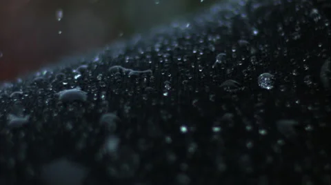 Water droplets bounce off on a high-tech sweater in the rain. Close up. Stock Footage