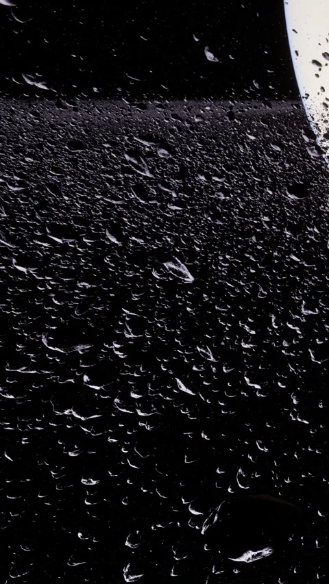 Water droplets collect on a dark surface during rainy weather in the evening Stock Footage 342112630