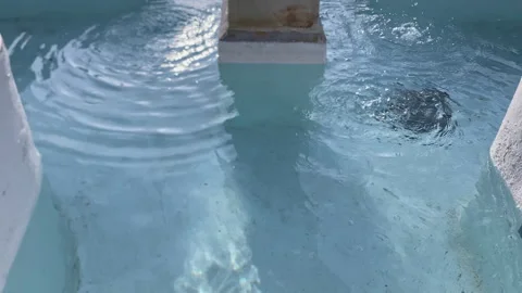 Water droplets continuously falling into a weathered stone fountain, creating Stock Footage 329667534