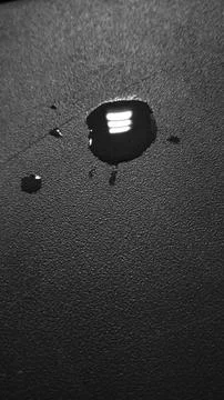Water Droplets on Dark Surface with Reflected Tripundra Shiva Stock Photos