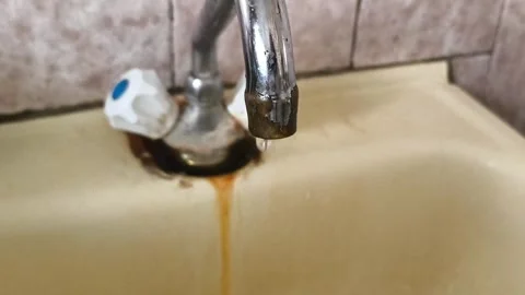 Water droplets drip from an old rusty kitchen faucet in close-up. Lack of Stock Footage 325287522