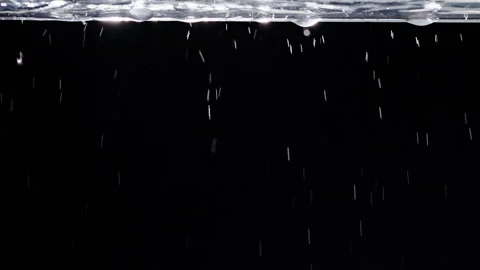 Water Droplets Fall Beneath a Rippling Surface Against Black Background, Creatin Stock Footage 341413283