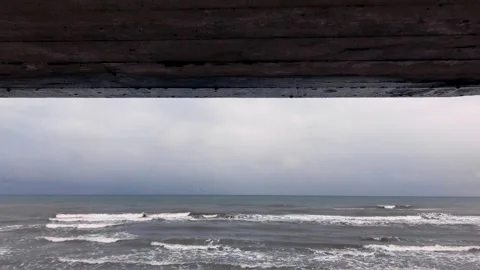 Water droplets fall from a concrete structure overlooking the sea Stock Footage 336247254