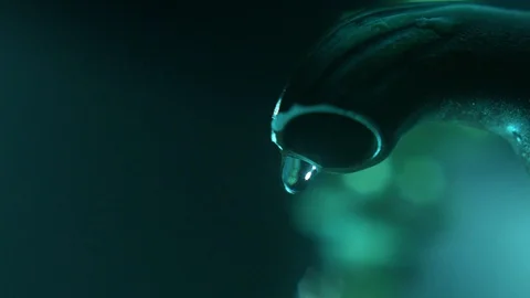 Water droplets fall of an old tap in close up and slow motion. Stock Footage 128003704