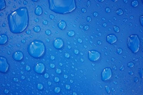 Water droplets form a vivid pattern on blue Foto stock