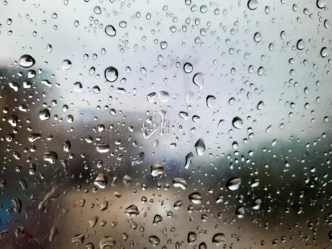 Water Droplets on Glass Window with Blurred Cityscape Fotos de archivo