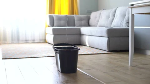 Water droplets leaking in bucket from ceiling, damaged roof, house renovation Stock Footage 115929078
