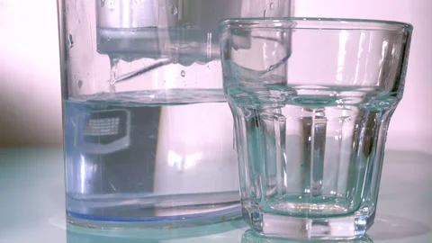 Water droplets in a plastic filter jug, next to a glass tumbler. Stock Footage 244806761
