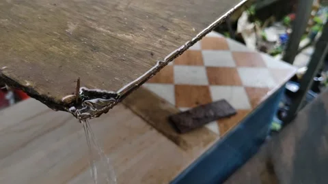 Water droplets running down the edge of a damp wooden surface Stock Footage 304056613