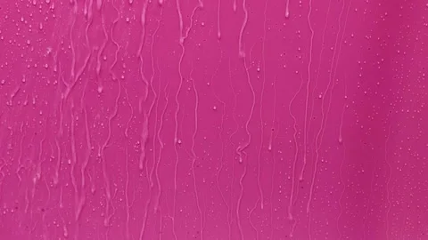 Water droplets running down a pink background at different angles Stock Footage 340461712