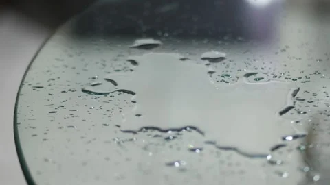 Water Droplets Splashing on Glass Table Surface in Close Up 動画素材 339002002