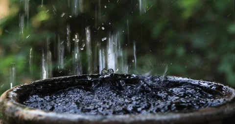 Water droplets into a water jar creating gentle splashes and ripples Stock-Footage 334672289