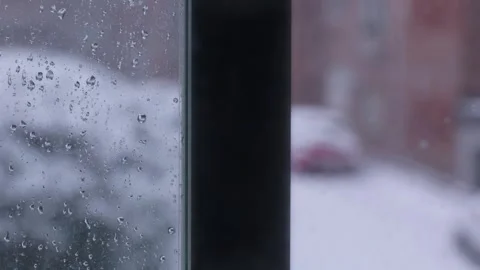 Water droplets on window glass during snowfall Stock Footage 346687079