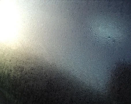 Water droplets on a window with sunlight reflection Stock Photos