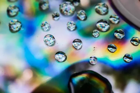 Water is dropping on the CD discs and red, blue and yellow lights are coming 库存照片