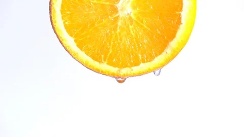 Water dropping on an orange fruit in slow motion. Stock Footage 94387495