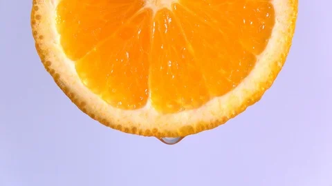 Water dropping on an orange fruit in slow motion. Stock Footage 94389515