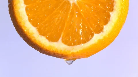 Water dropping on an orange fruit in slow motion. Stock Footage 94391352
