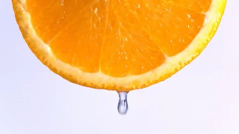 Water dropping on an orange fruit in slow motion. Stock Footage 94392232