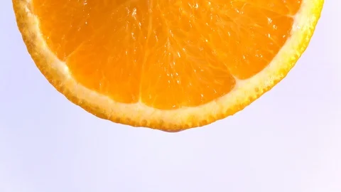 Water dropping on an orange fruit in slow motion. Stock Footage 94392576