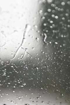 Water dropplets streaming down window in rain Stock Photos