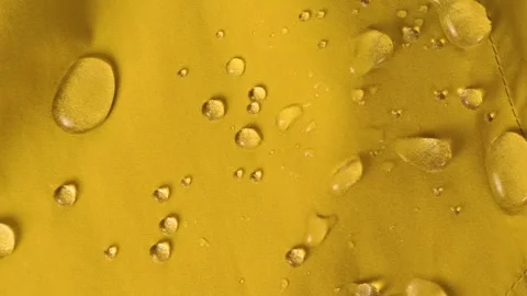 Water drops are dripping on yellow hydrophobic fabric. Stock Footage 345264841
