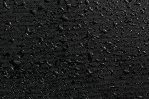 Water drops on black flat rubber surface macro background Foto stock