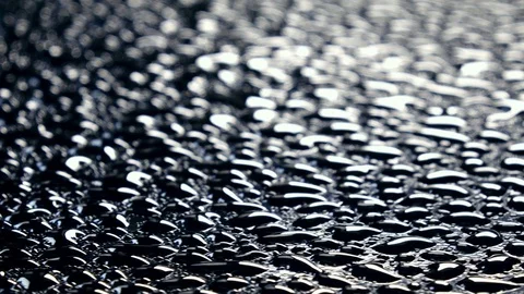 Water drops on black surface with front focus, rotating contra clockwise Video stock 78351849