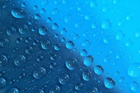 Water drops on the blue surface. Selective focus. Stock Photos
