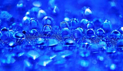 Water drops on the blue textured surface Stock Photos