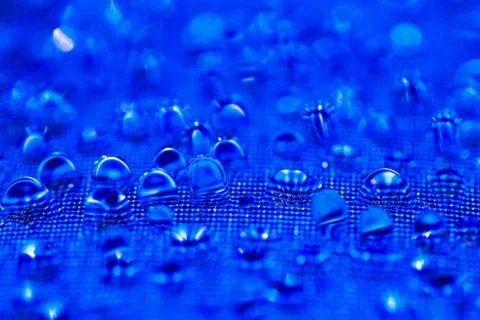 Water drops on the blue textured surface Stock Photos