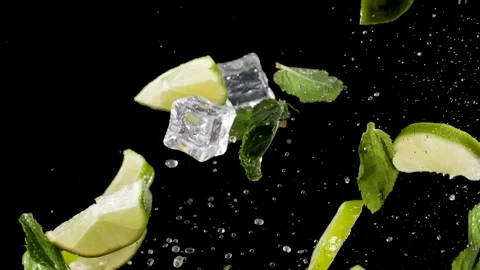 Water drops, chunks of lime and mint fly up, on a black background, close-up Stock Footage 144334549
