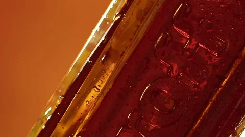 Water drops on the cooled bottle of brandy or whiskey on brown background. Close Stock Footage 96238672
