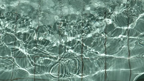 Water drops creating an abstract light pattern in a pool Stock Footage 162783164