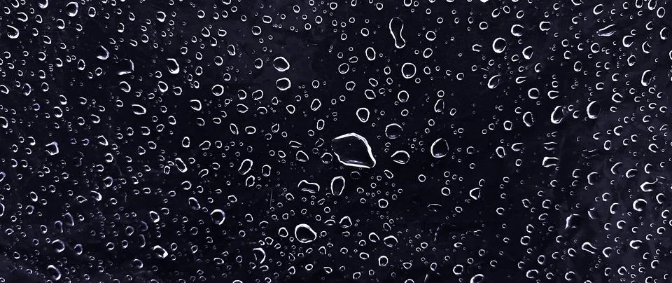 Water drops on dark surface background texture with condensation and rain d.. Stock Photos