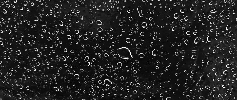 Water drops on dark surface background texture with condensation and rain d.. Stock Photos