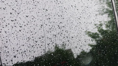 Water drops during rain roll down the side window of a car. 스톡 동영상 313371020
