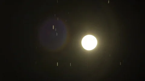 Water drops fall in foreground in slow motion, a lantern shines in background Video stock 129358198