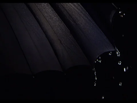 Water drops falling on a black umbrella, 4 segments visible, slow motion Stock Footage 74217948