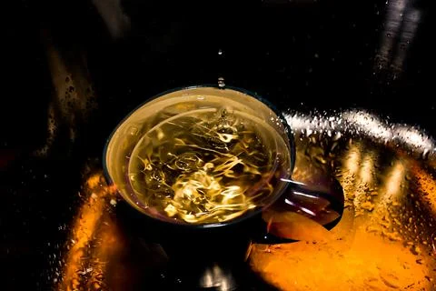 Water drops falling into the cup Stock Photos