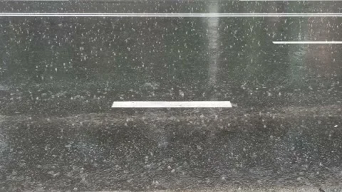 Water drops falling down onto asphalted road during raining Video stock 159765699