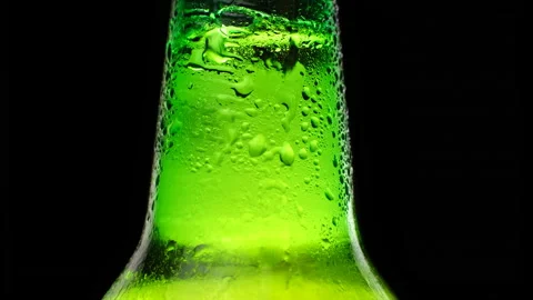 Water drops falling down on the glass of beer. Dater drops on green glass close Stock Footage 153319061