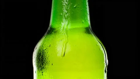 Water drops falling down on the glass of beer. Water drops on green glass  Stock Footage 153933991
