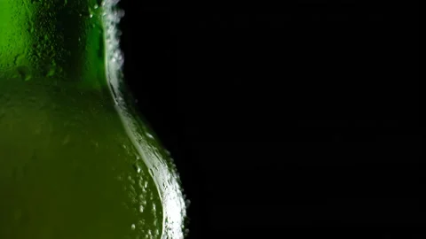 Water drops falling down on the glass of beer. Water drops on green glass Stock Footage 155391736