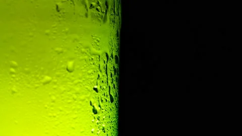 Water drops falling down on the glass of beer. Water drops on green glass Stock Footage 163795431